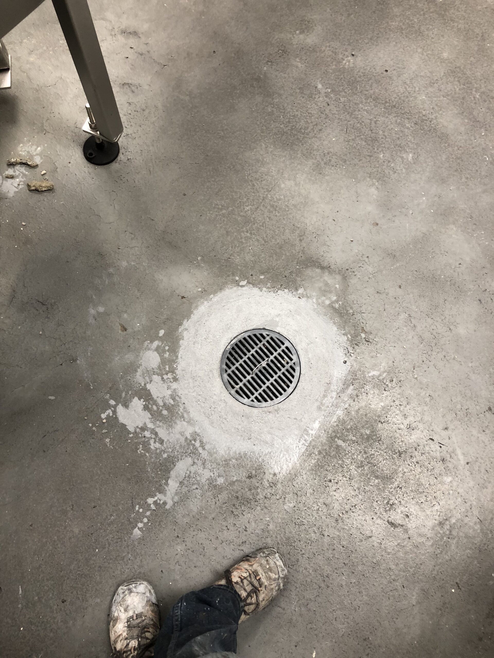 Close-up of a repaired concrete floor with a drain. — warehouse floor resurfacing when needed