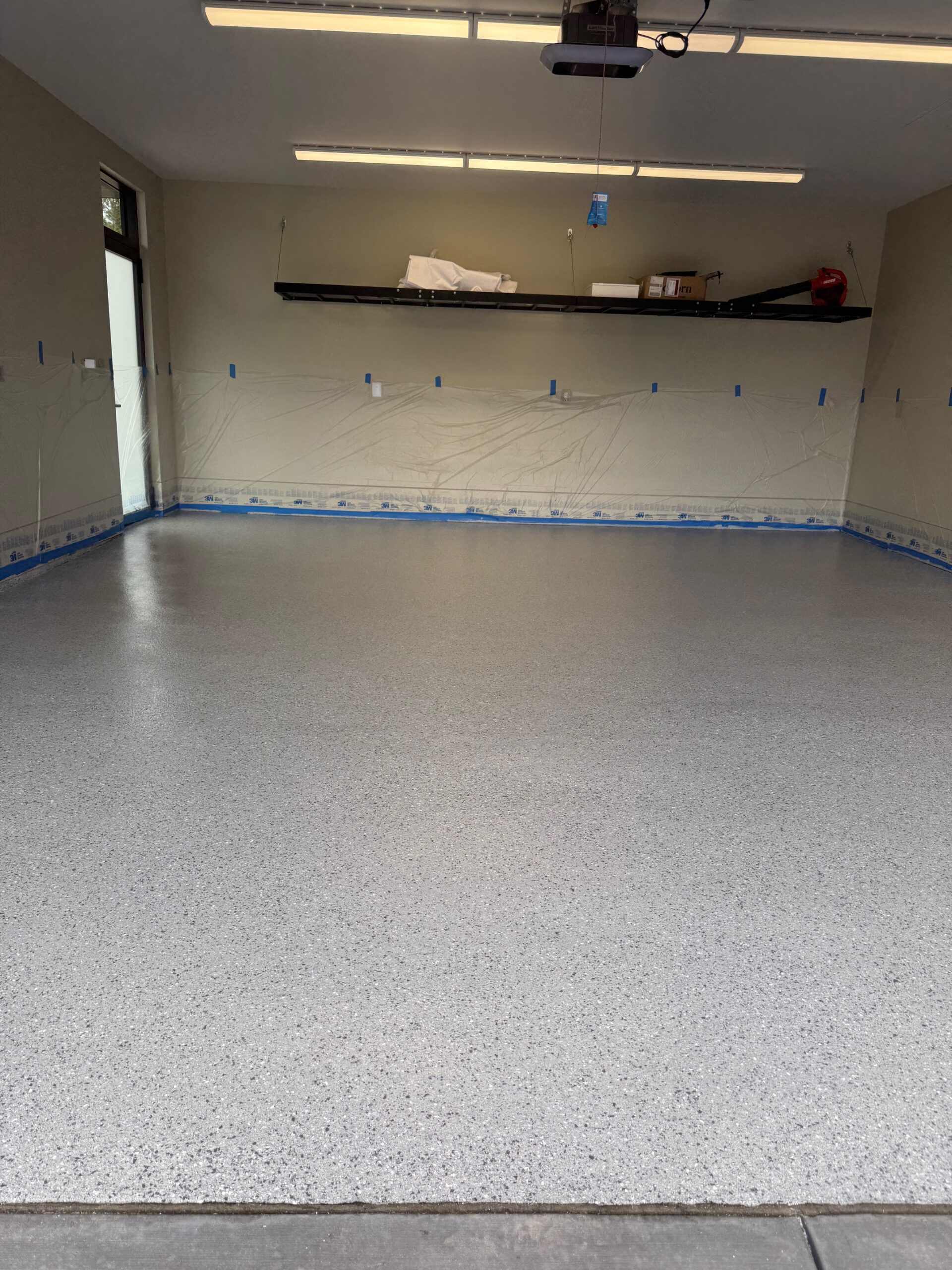 A newly applied flake broadcast epoxy floor in a garage.