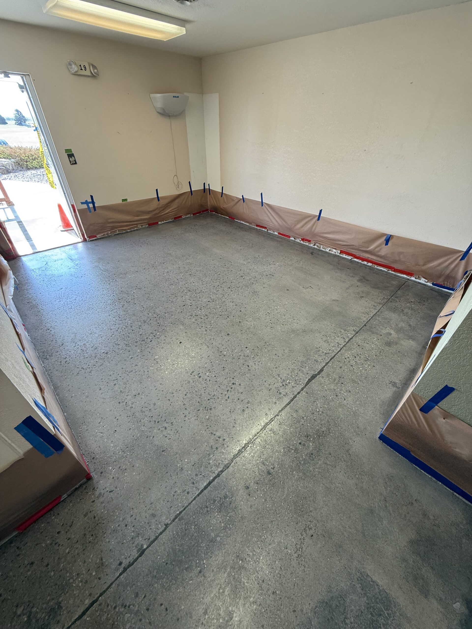 A polished concrete floor in a food processing area, with protective barriers along the walls. — polished concrete process levels explained