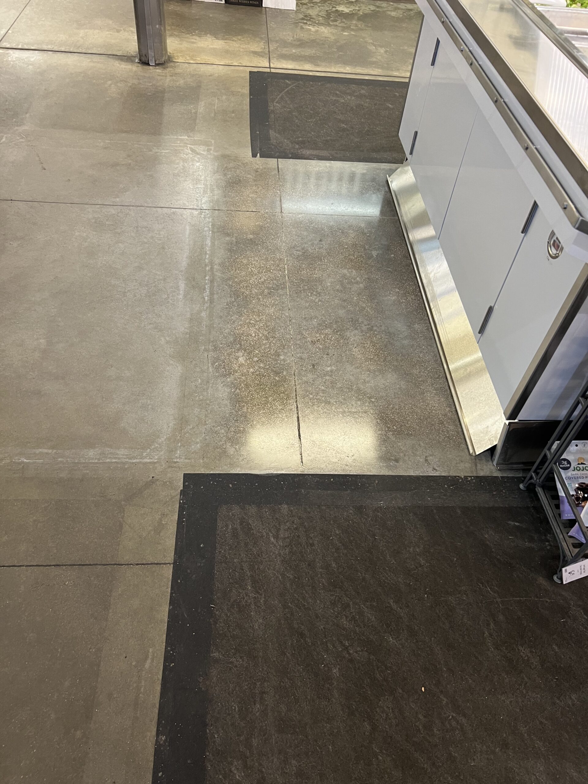 Polished concrete floor with visible repair area in a food processing setting. — polished concrete process levels explained