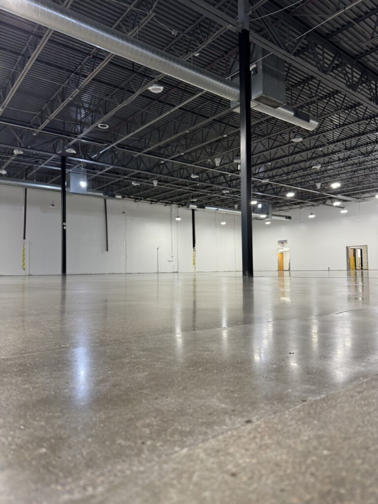 Polished concrete floor with exposed aggregate in a large open warehouse space