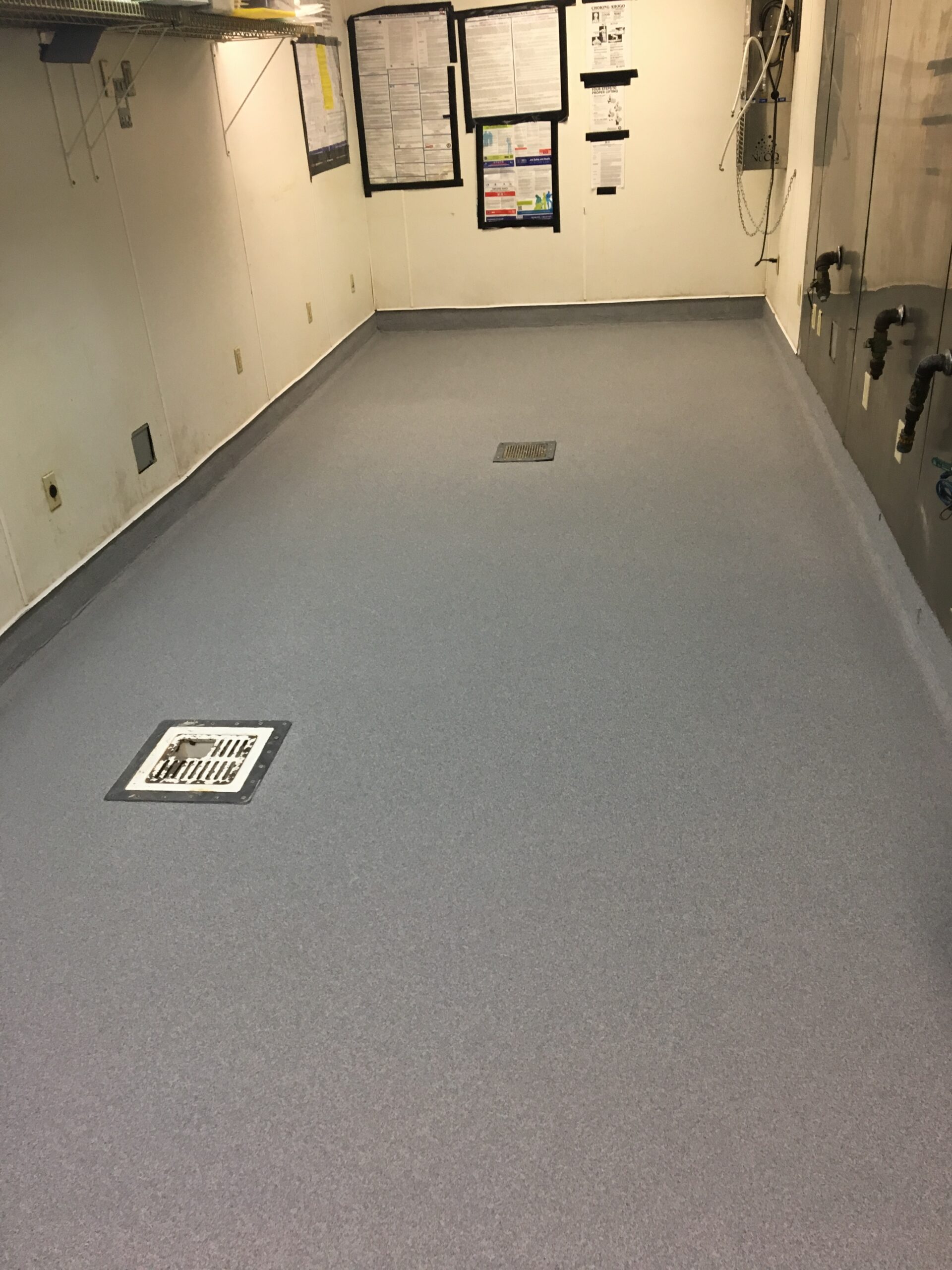 A clean quartz broadcast epoxy floor with a drain in a food processing area.