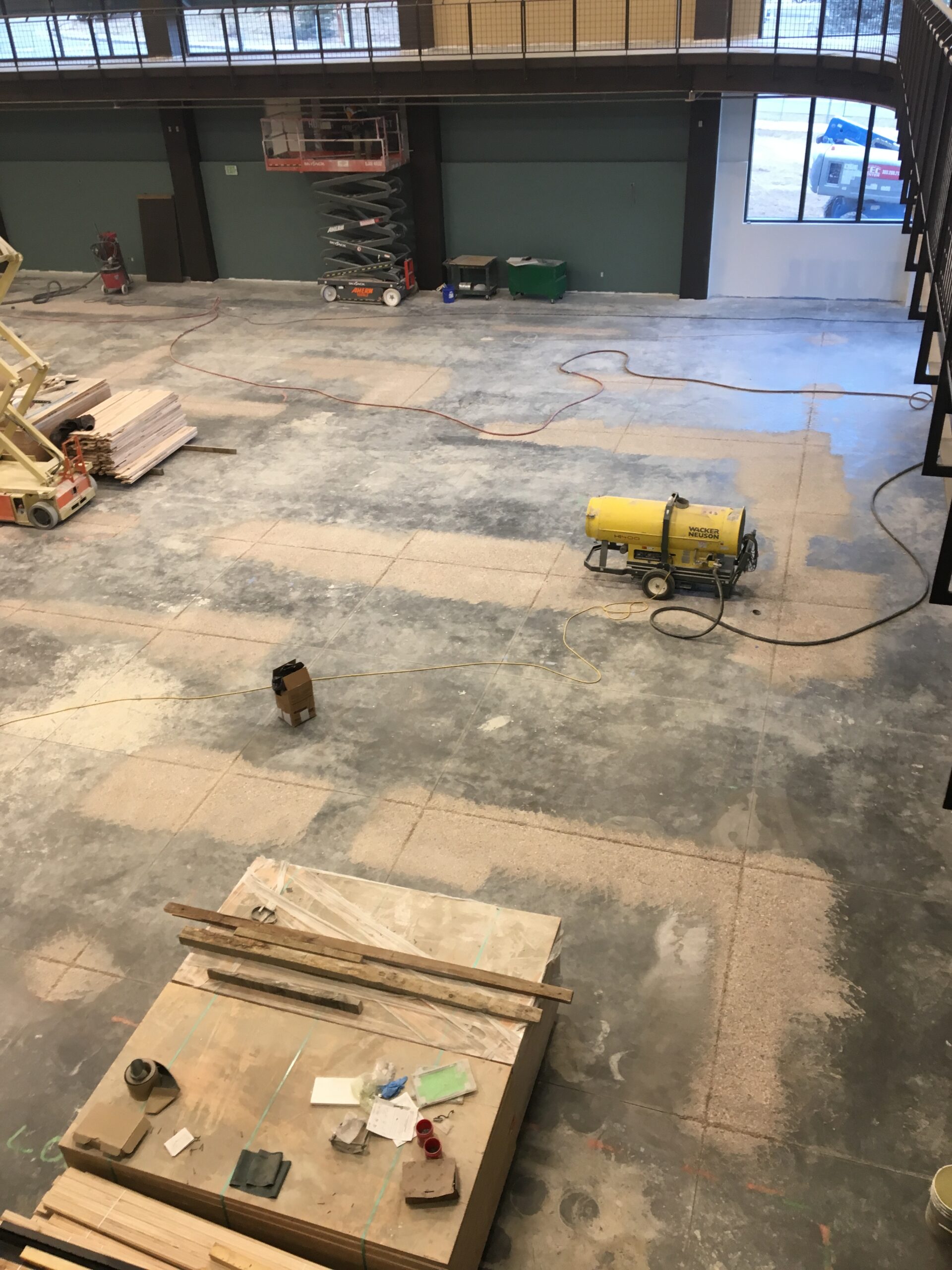 A view of a concrete grinding process in a large industrial space. — commercial concrete grinding Denver