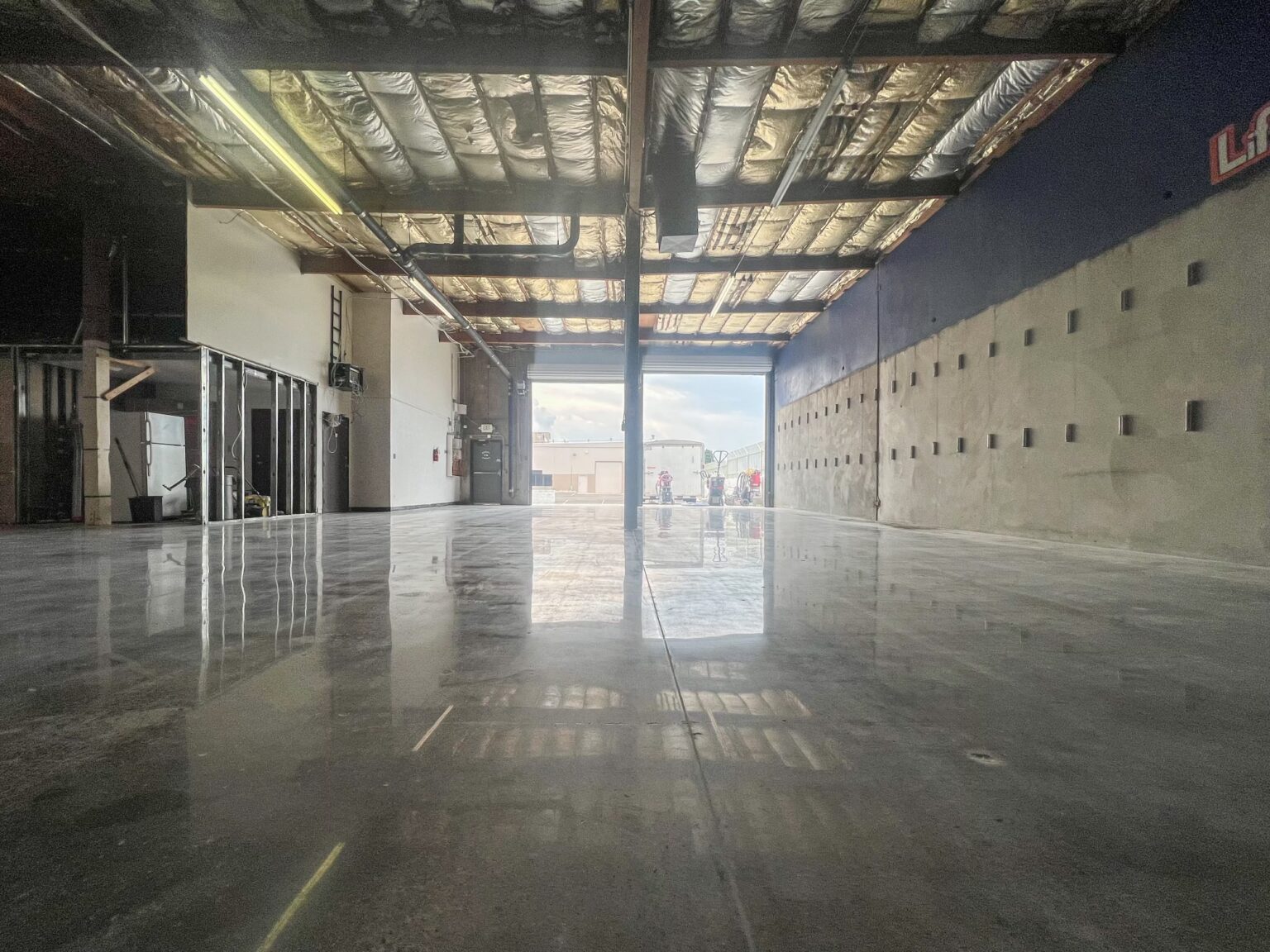 A polished concrete floor in a large industrial space with natural light