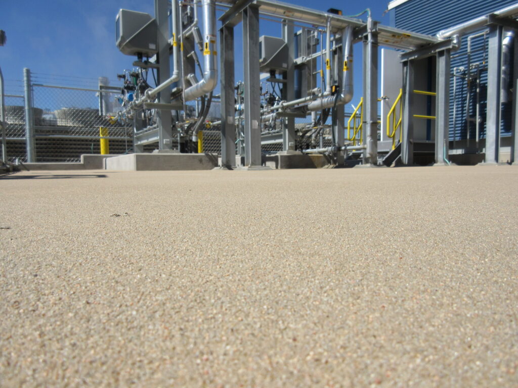 A close-up view of a quartz broadcast epoxy floor in an industrial setting.