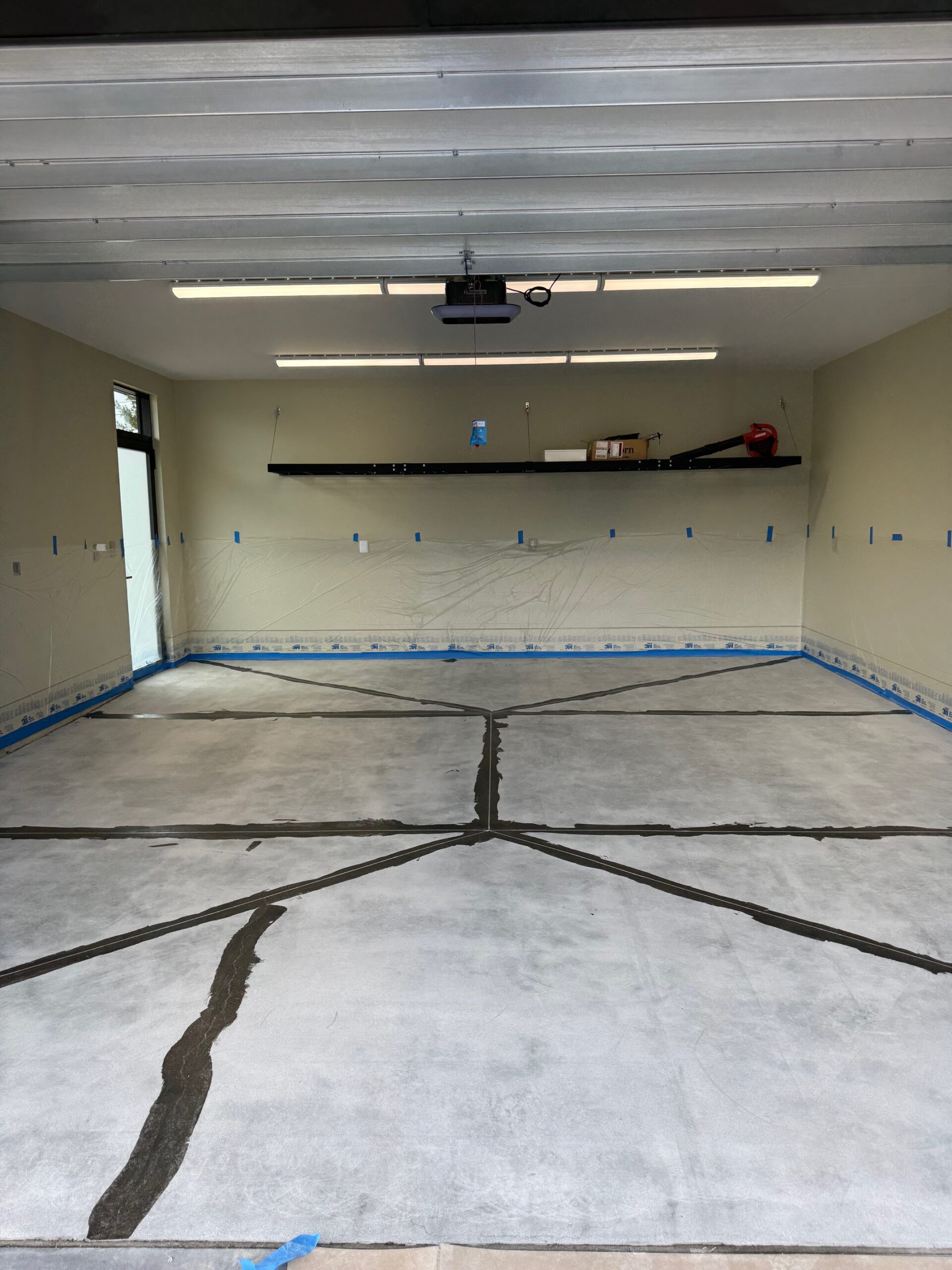 A garage floor prepared for epoxy coating with marked sections. — epoxy flooring indoor air quality
