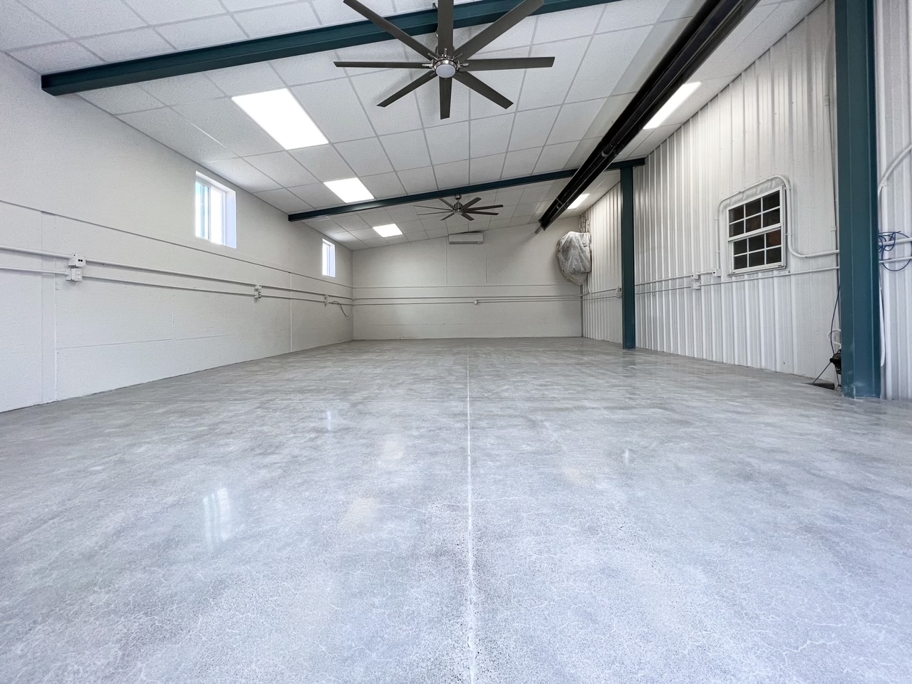 Three red trucks parked in a maintenance garage with a polished concrete floor