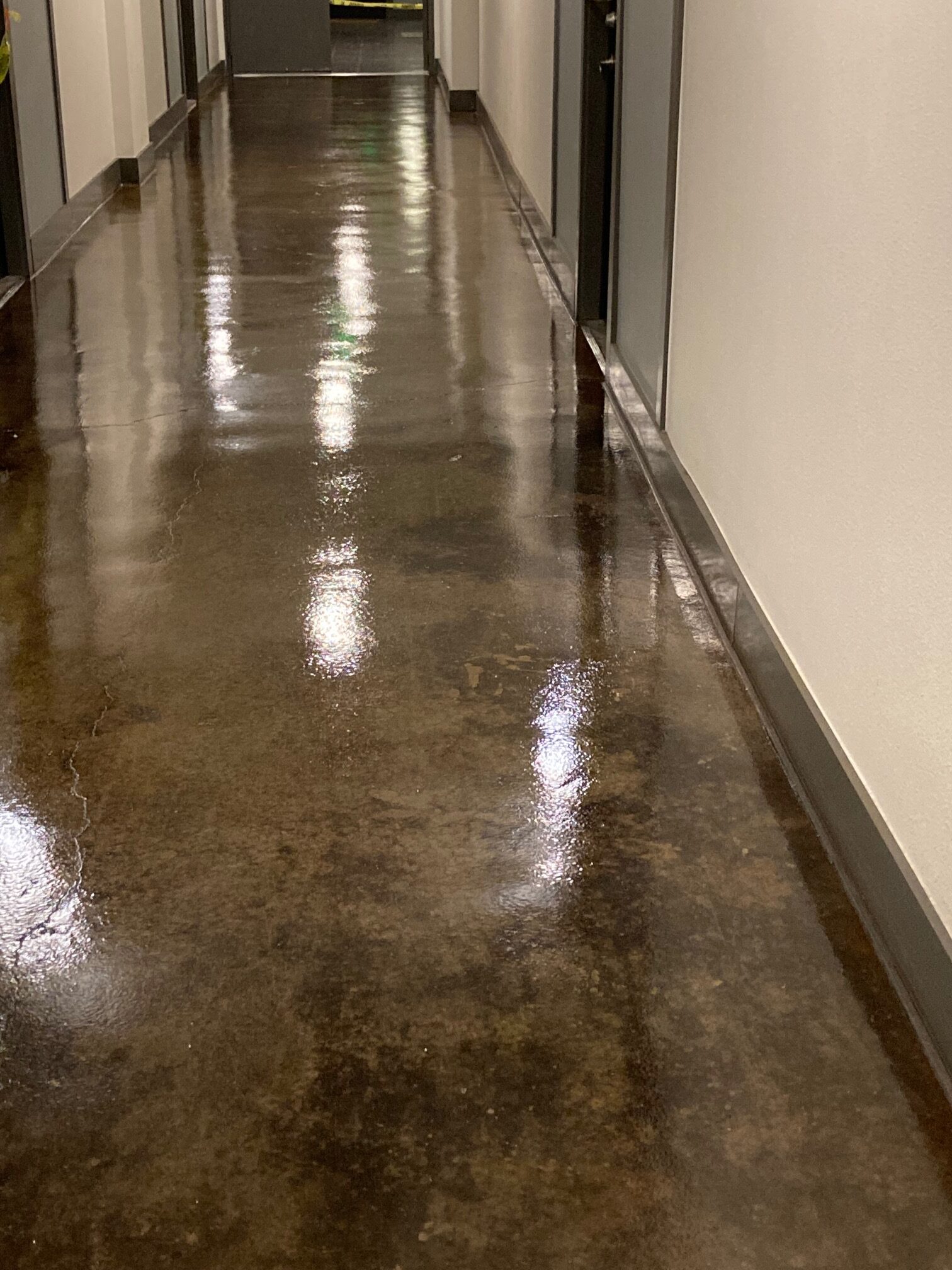 A polished concrete hallway with a reflective surface.