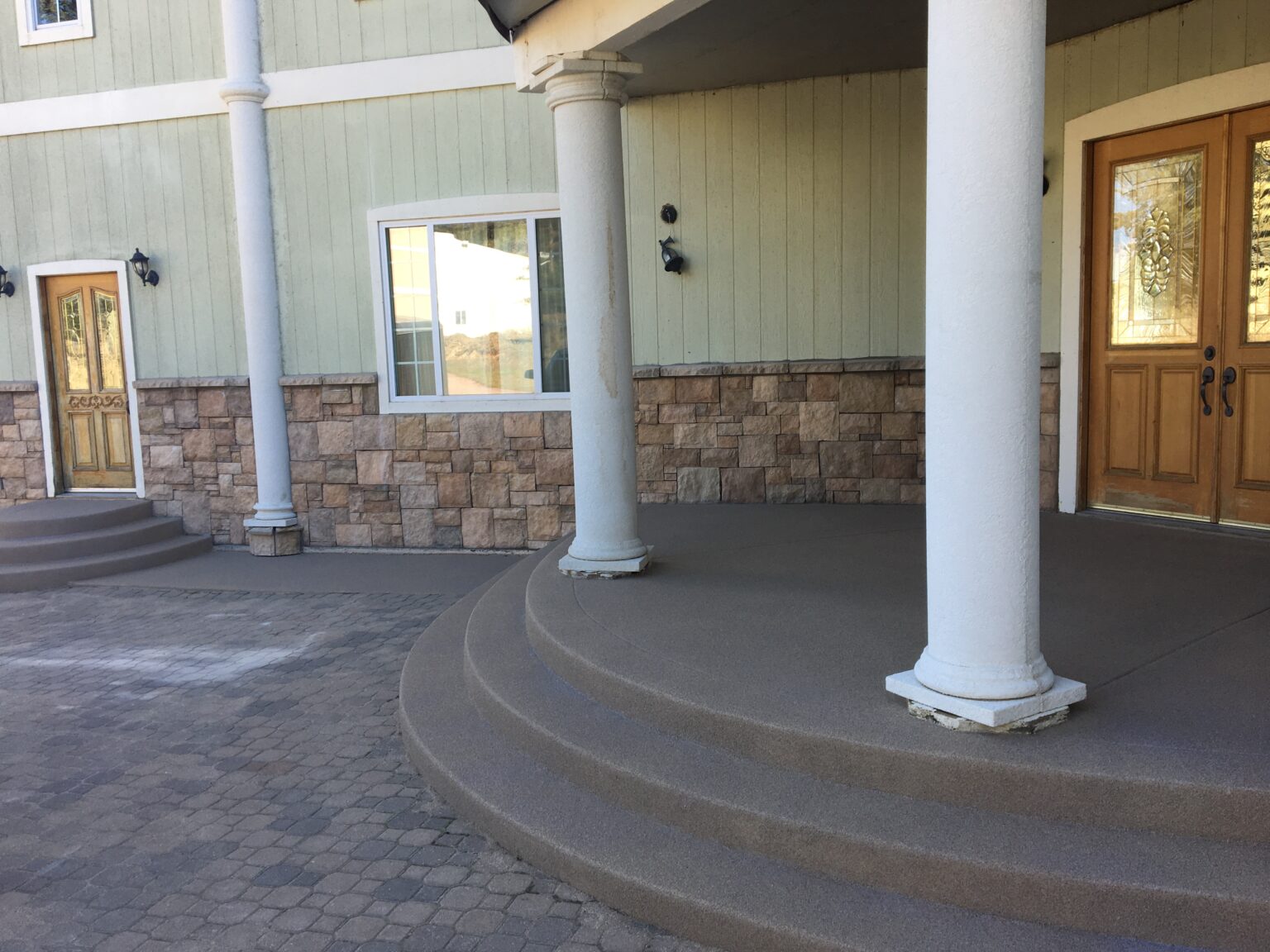 Front entrance porch and curved steps finished in a tan quartz broadcast epoxy coating