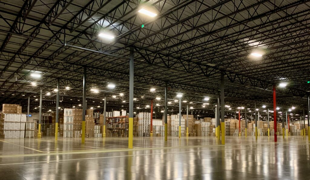 A spacious warehouse interior with polished concrete flooring and stacked boxes.