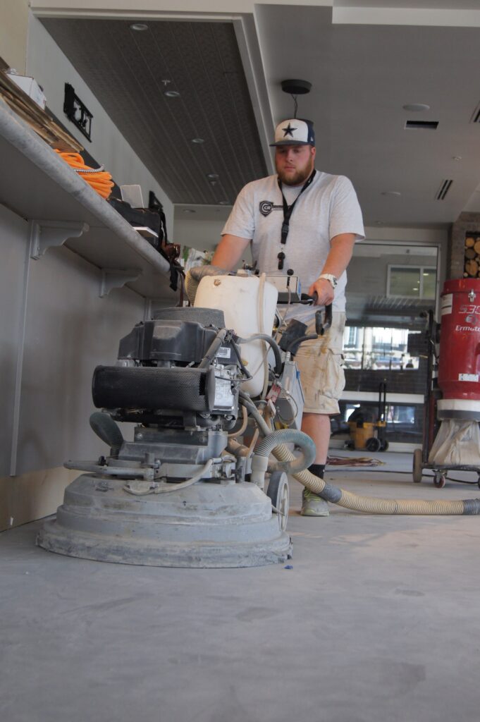 CCR technician operating a floor grinding machine in a commercial space