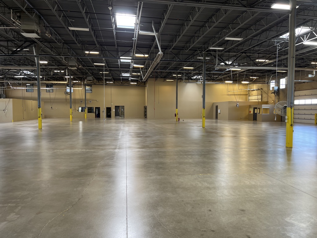 A view of a concrete grinding process in a large industrial space. — commercial concrete grinding Denver